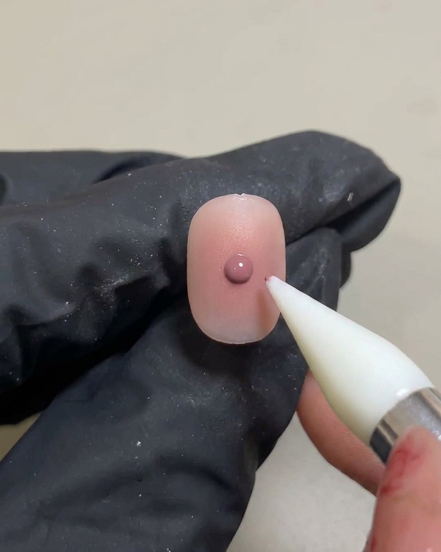 一度硬化させたチークグラデーションの上に、シリコンツールでさらに小さなピンクジェルを乗せている様子