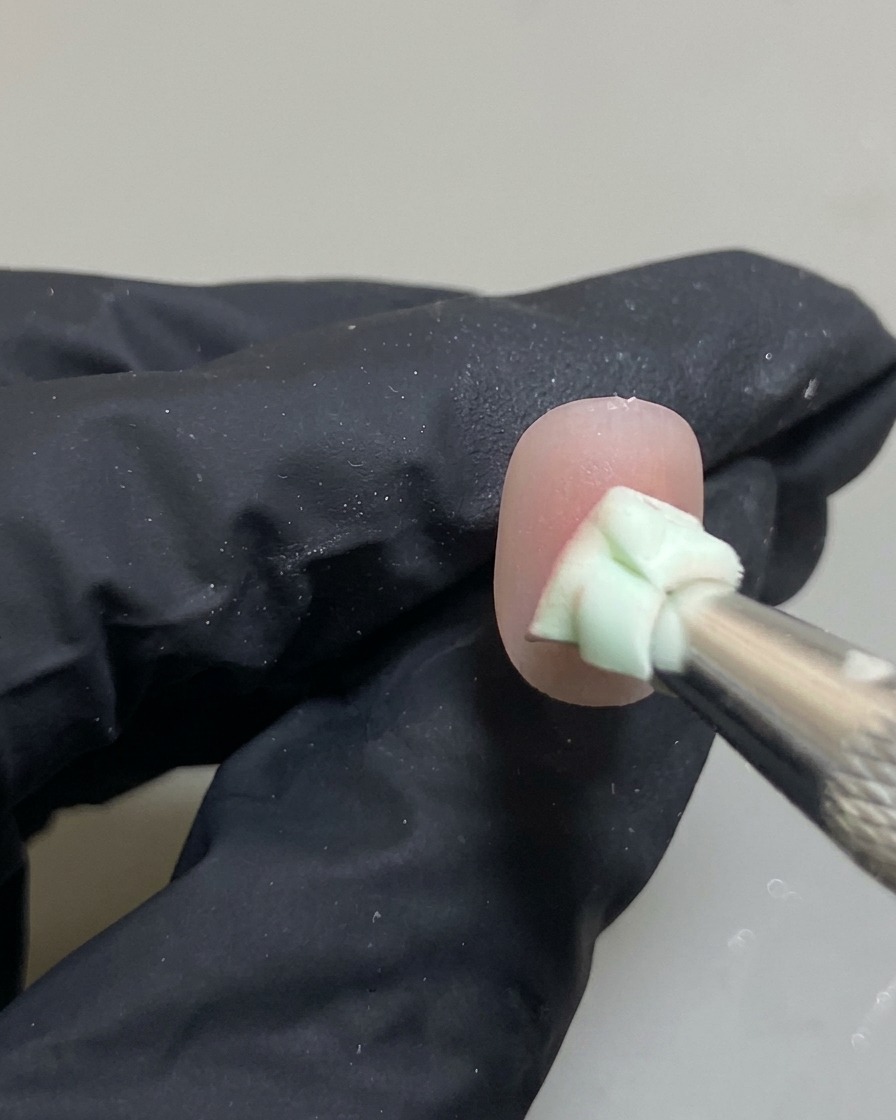 スポンジを使って、爪の中心に乗せたピンクジェルをグラデーションになじませている様子