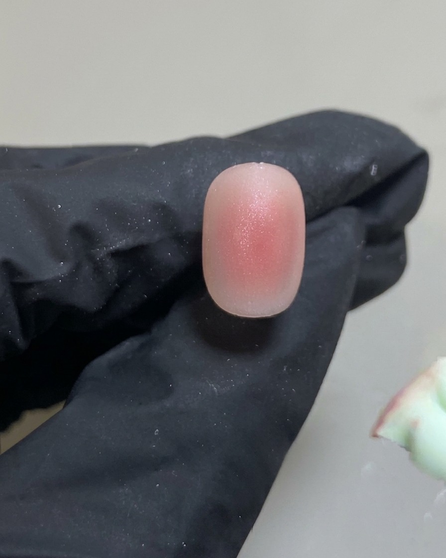 シリコンツールを使って、爪の真ん中にピンクジェルをごくわずかに乗せている様子