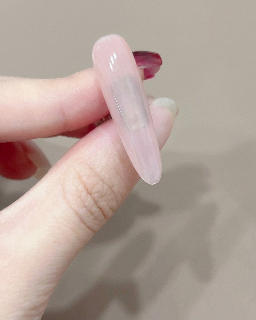 小型の手持ち式UVライトで1本のネイルを硬化している様子。