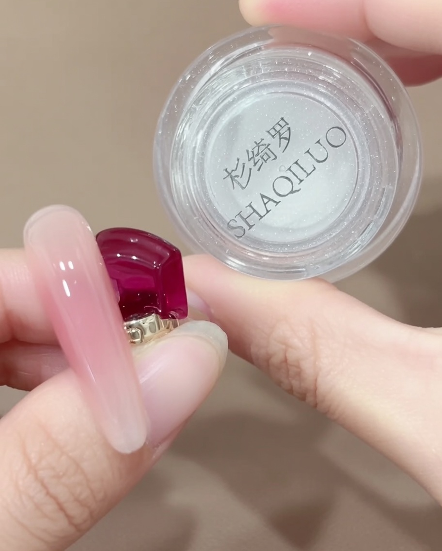 シリコンブラシを使って容器から少量のオーロラクロムパウダーをすくい取っている様子。