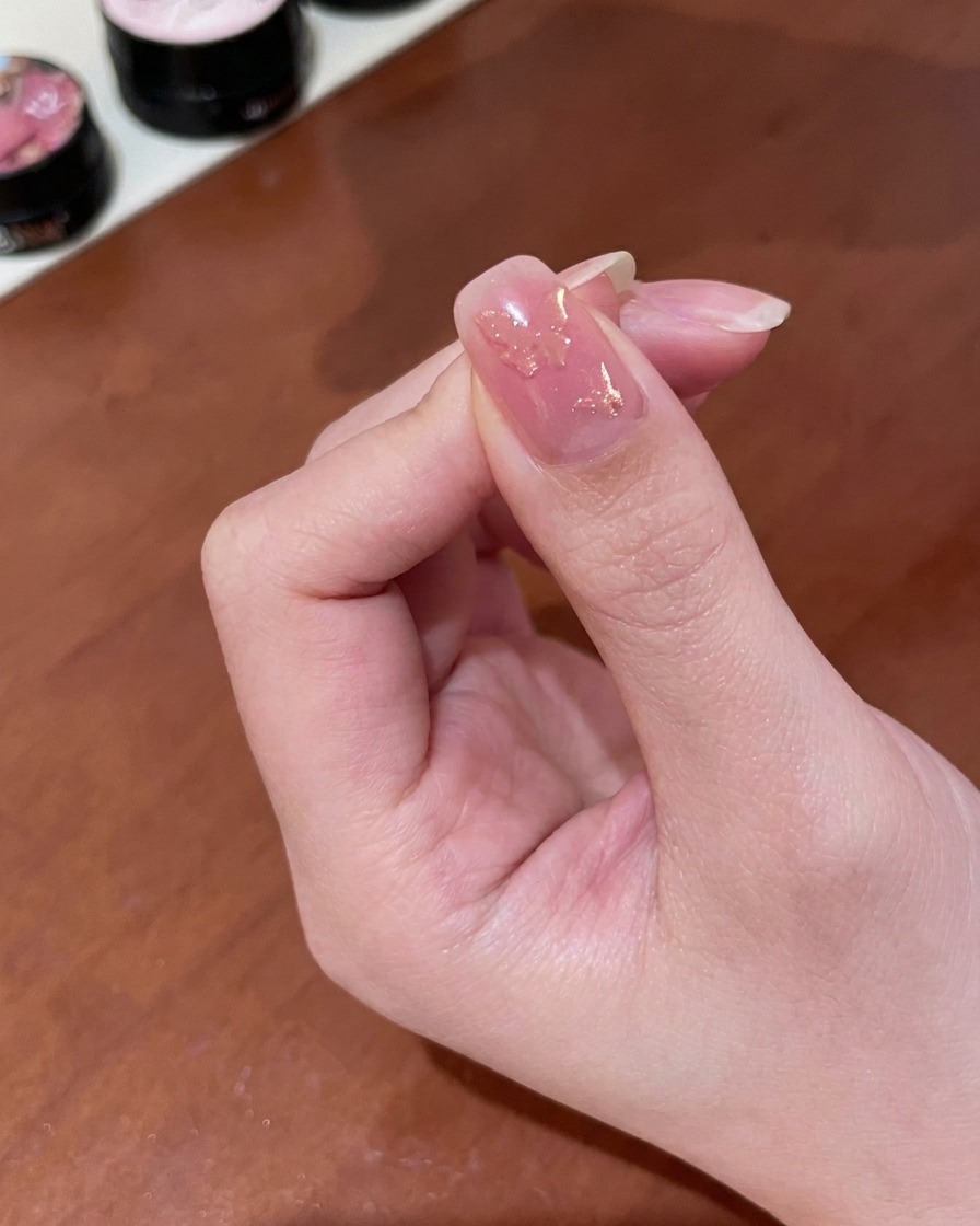 マグネットを爪に近づけ、ゴールドの粒子を動かしている様子。