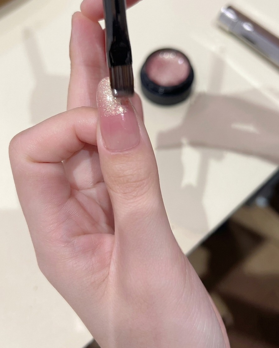 筆を使って爪の先端部分にキャッツアイジェルを乗せ、少し中央に向かってぼかしている様子。