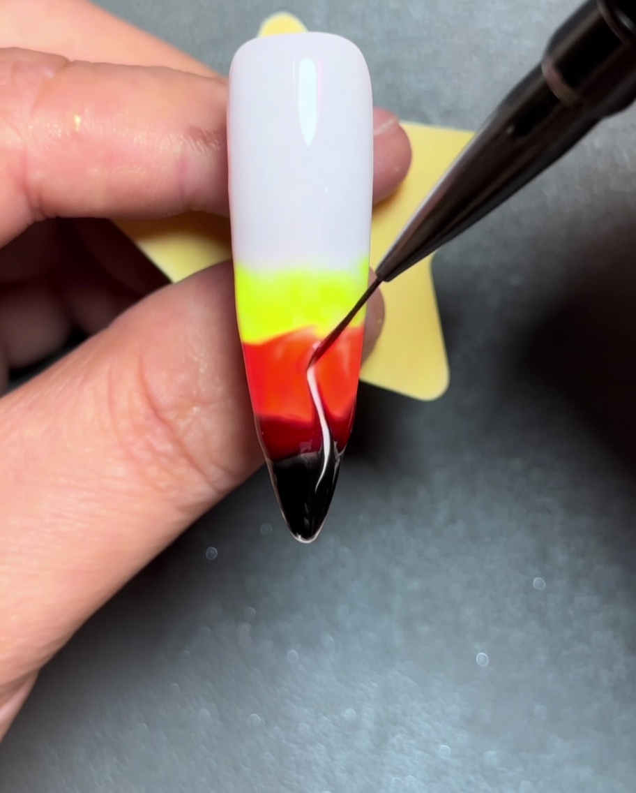 ライナーブラシで濡れたジェルを上方向にドラッグし、炎の形を作っている様子