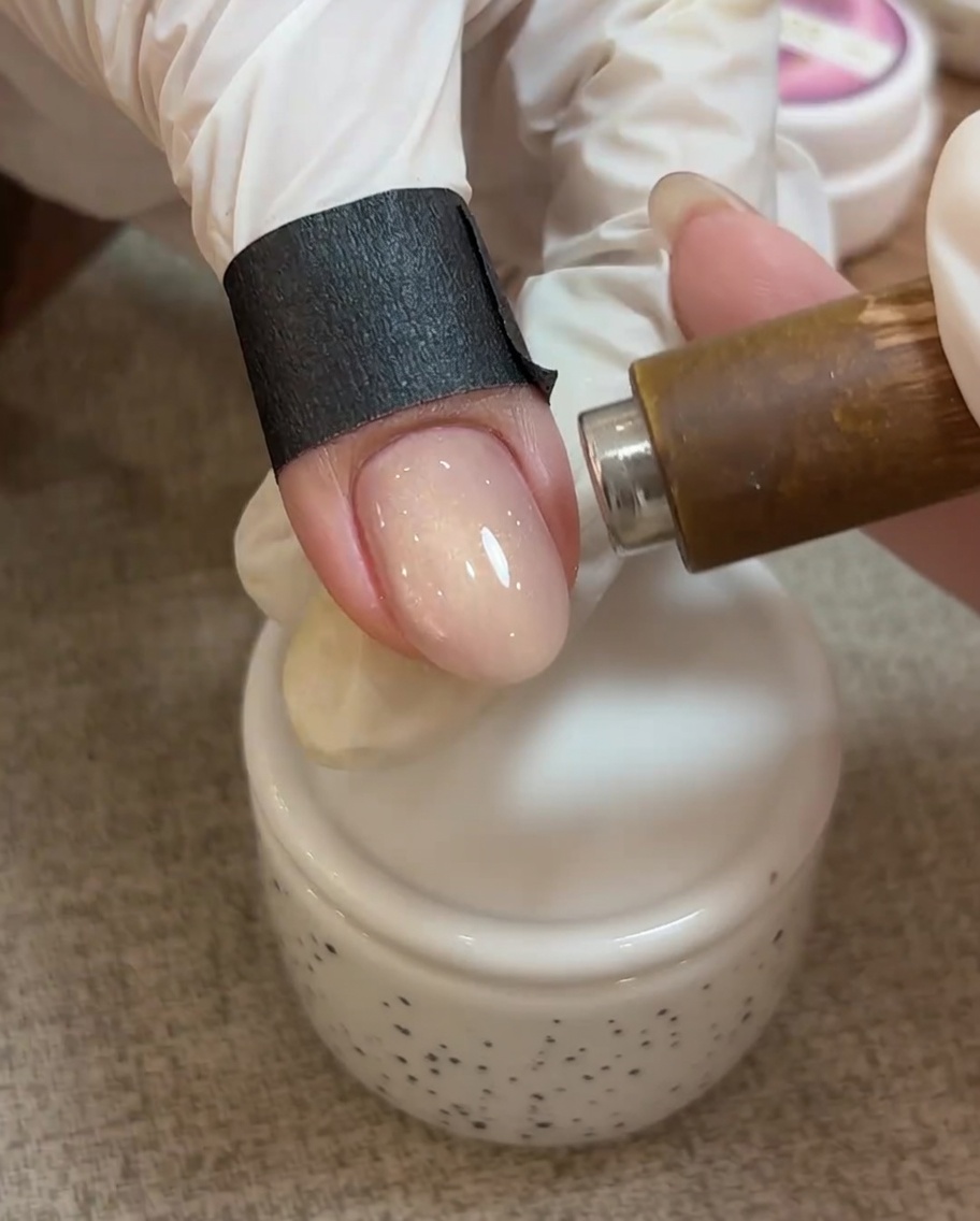 未硬化のキャッツアイジェルの上にマグネットをかざし、粒子が移動して光のラインが現れている接写。