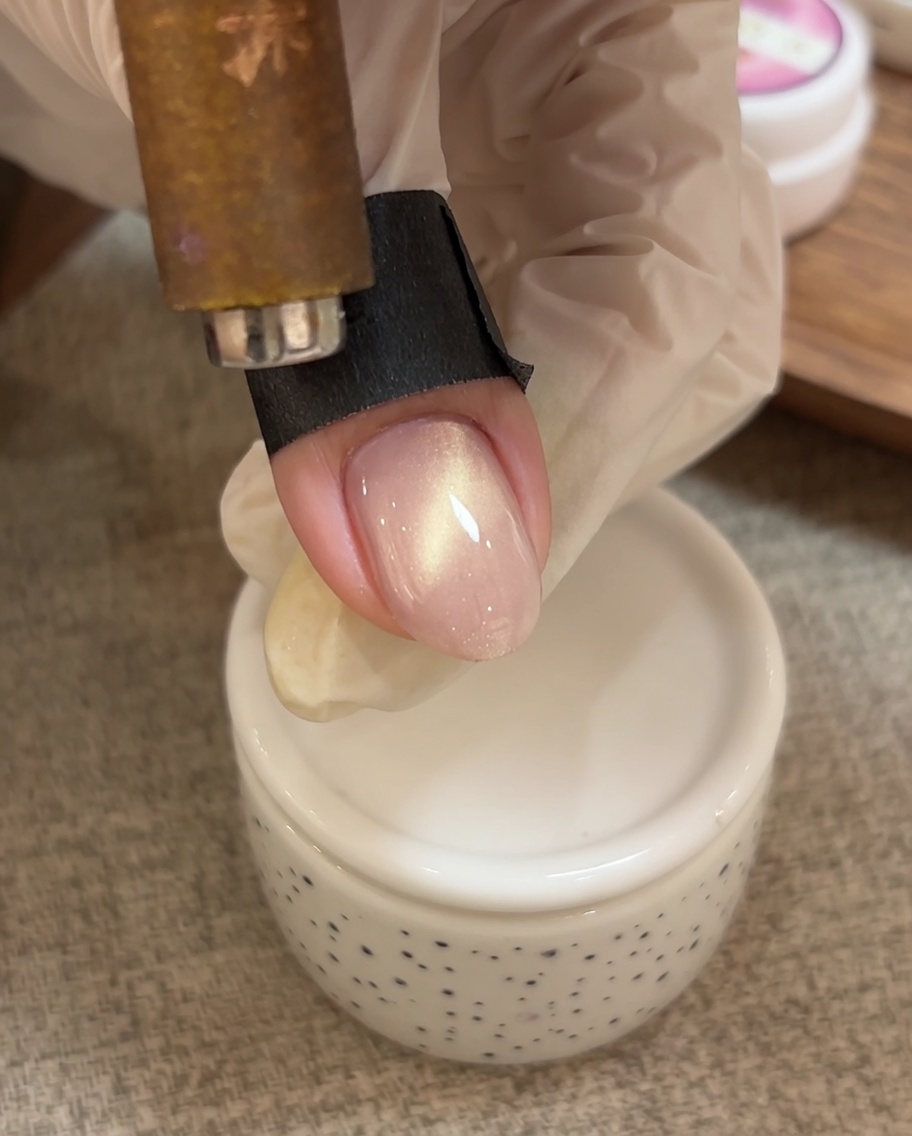 マグネットツールを使い、キャッツアイジェルの粒子を爪の先端に向けて押し寄せている様子。