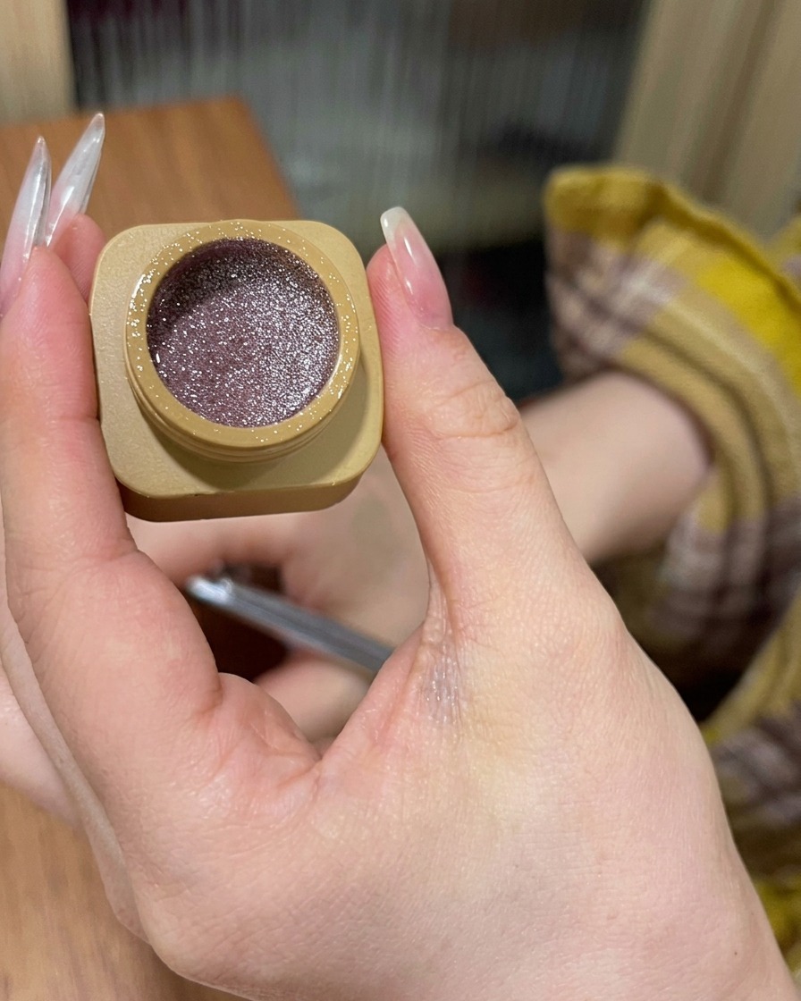 爪の根元にピンクグリッタージェルを塗り、先端に向かってぼかしている様子。