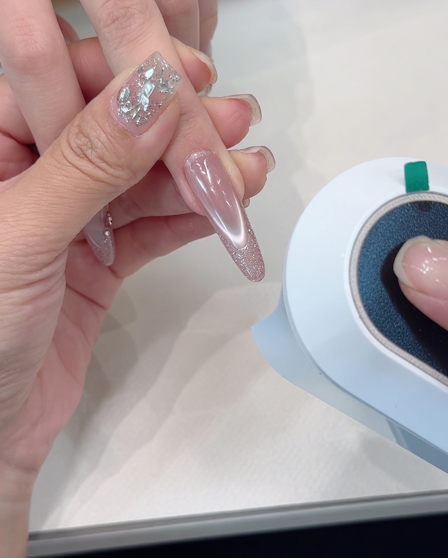 グリッターネイルを施した手をUV/LEDランプで硬化させている様子