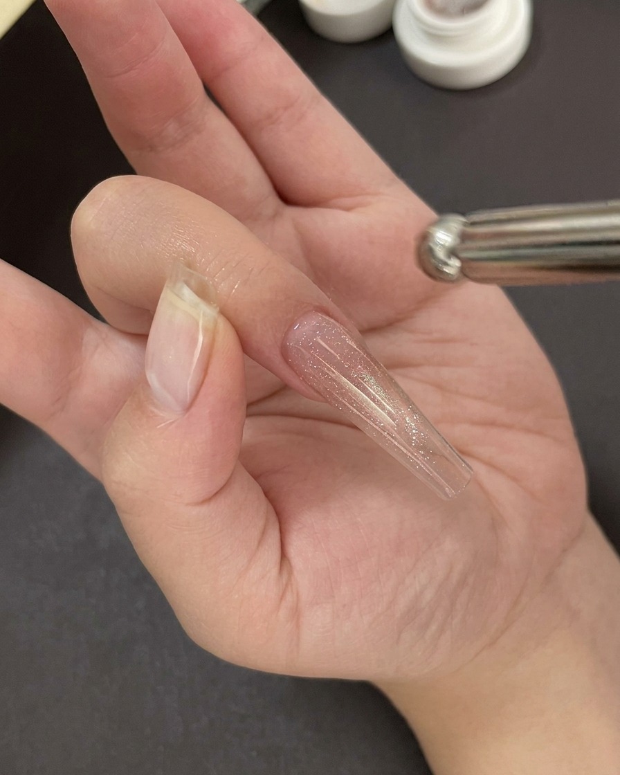 ジェルを硬化させるため、UV/LEDライトの中に手を入れている様子。