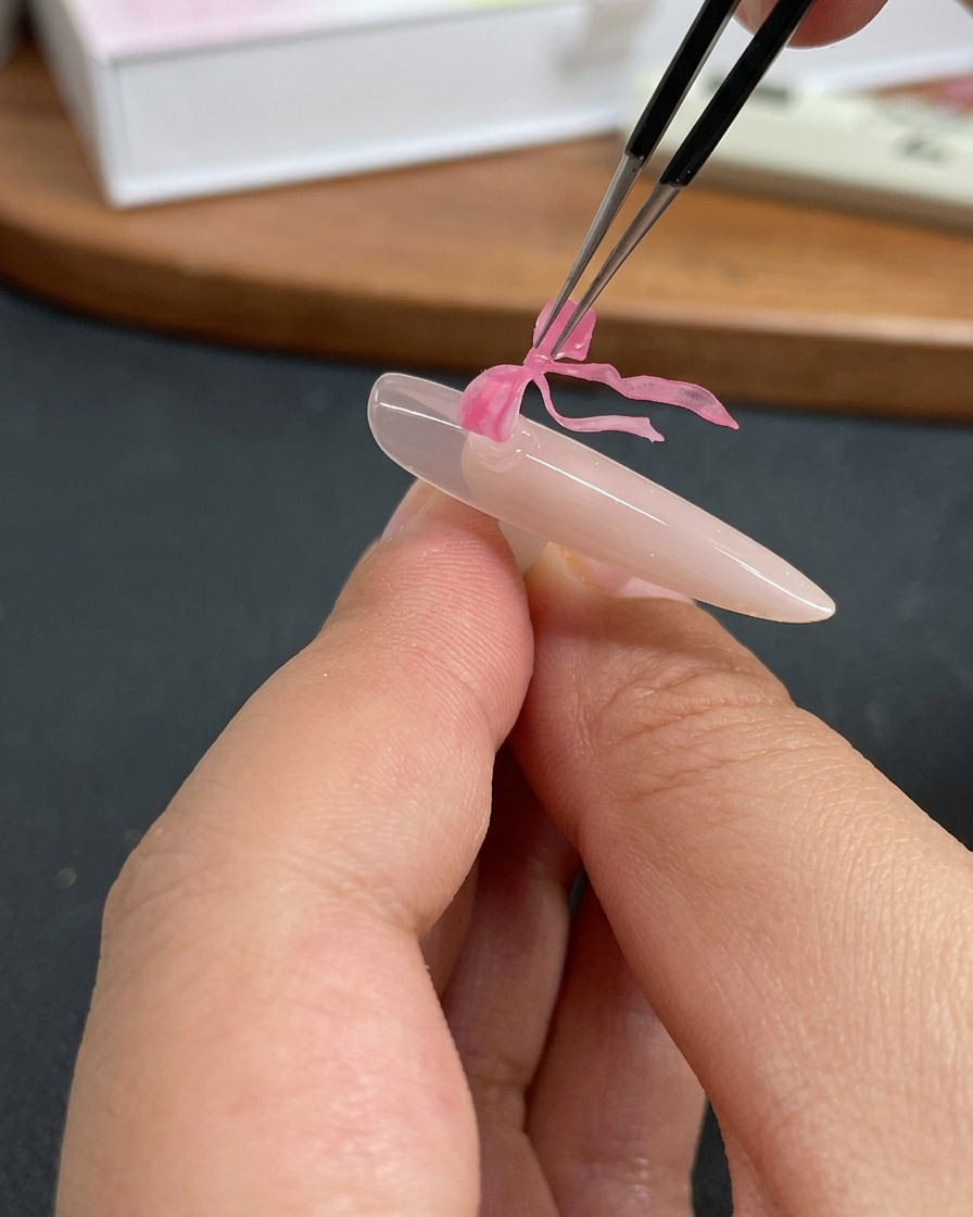 ピンセットで蝶のチャームをジェルの上に乗せている様子。