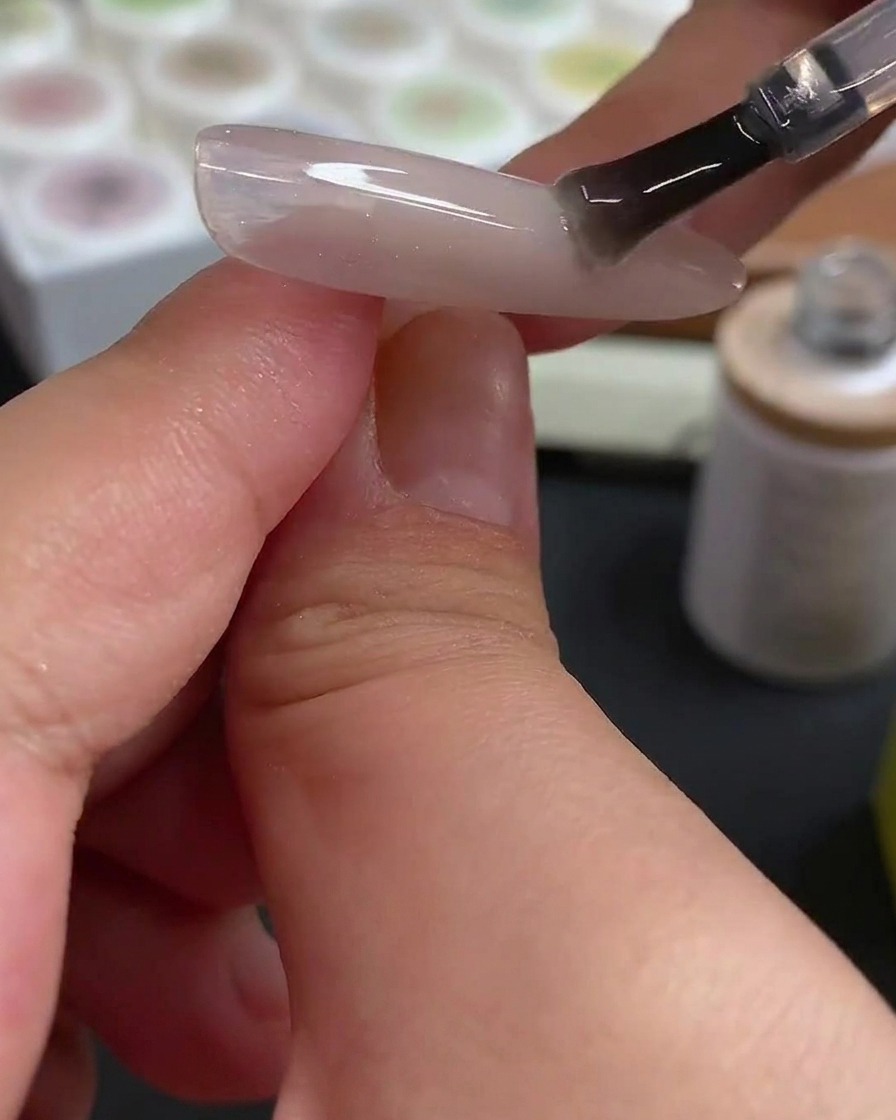 ドットペンでローズレッドのジェルを乗せ、水玉模様を作っている様子。