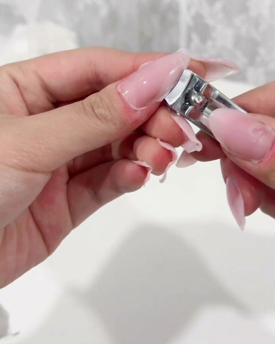 ネイルニッパーでクリアチップの先端をカットしている様子
