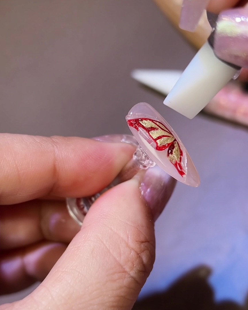シリコンツールを使って、3Dジェルを蝶の羽のシルエットに整える様子。