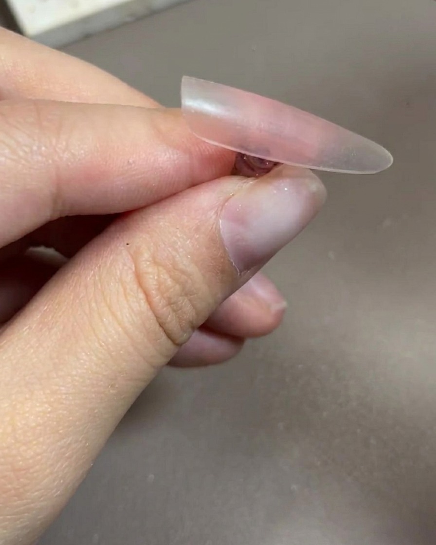 ライトの中に手を入れてベースジェルを硬化させている様子