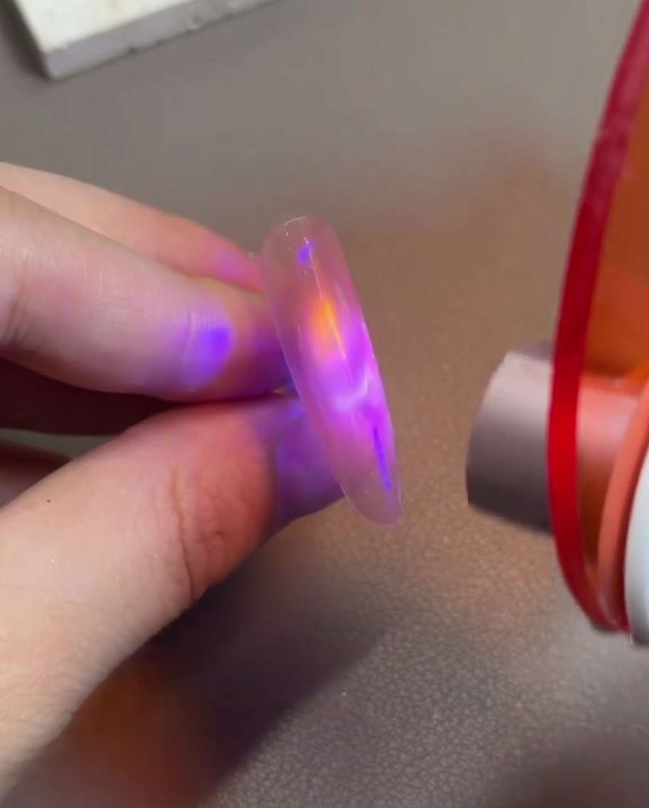 小型LEDライトで硬化させ、輝きを固定している様子