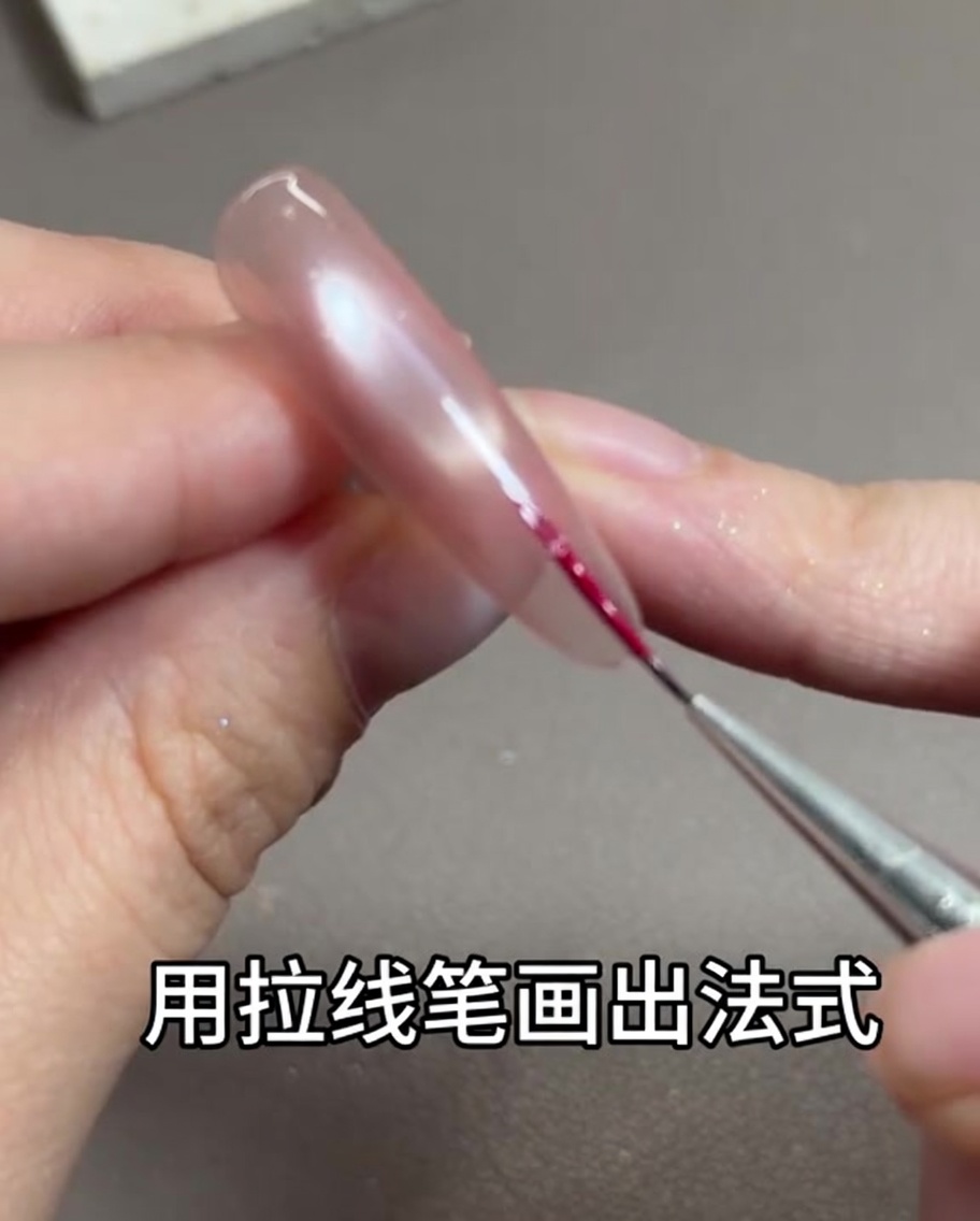 細いライナーブラシでローズレッドのラインを描いている様子
