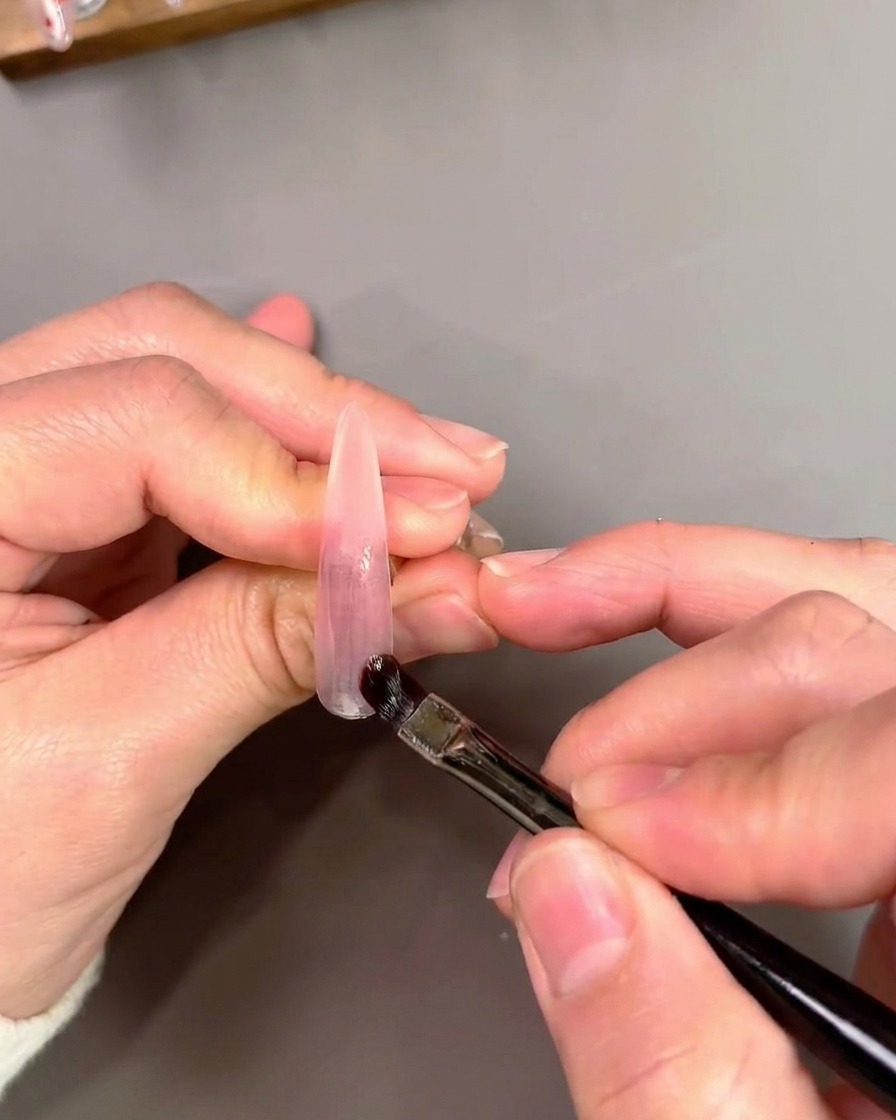 別の爪にパープルのキャッツアイジェルを塗る様子