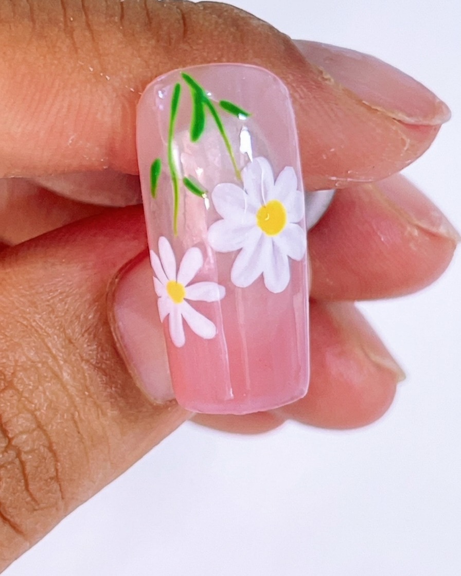 細筆でホワイトジェルを使い、ガイドラインに沿ってデイジーの花びらを描いている様子。