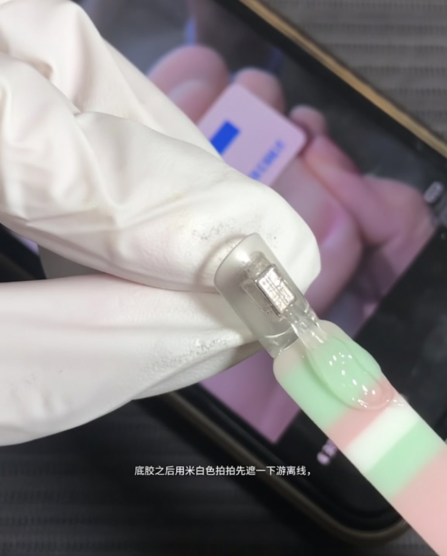 自爪の先端にミルキーホワイトのジェルを塗布している様子。