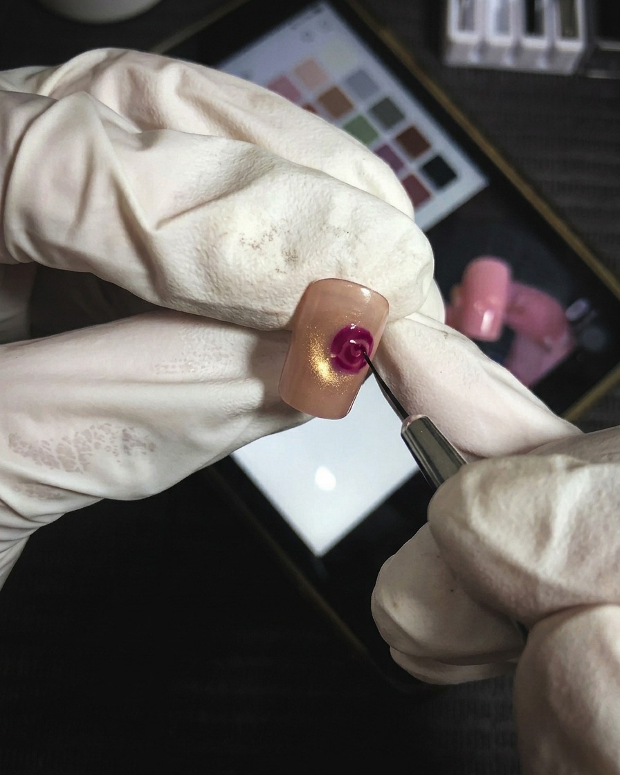 細い筆でマゼンタのジェルを使い、花びらの重なりを繊細な線で描き足している様子。