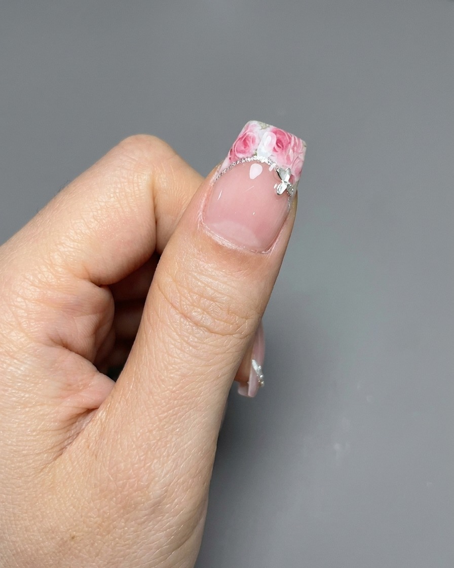 ピンセットでバラのシールをフレンチ部分へ丁寧に置いている様子。