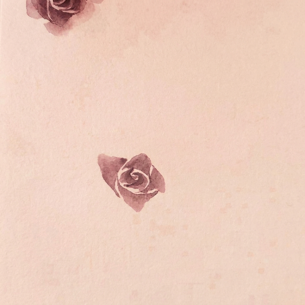 3層の花びらが重なって咲いている、紙に描かれた水彩のバラの様子。