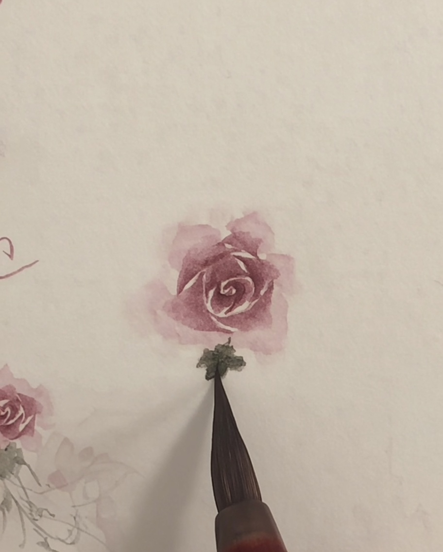 清潔な筆で紙に描かれたピンクの水彩画のバラの縁を軽くブレンドしている様子。