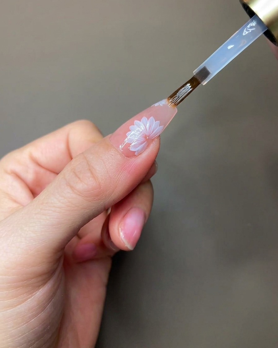 スカルプティングジェルを硬化するために手元をライトに入れている様子。