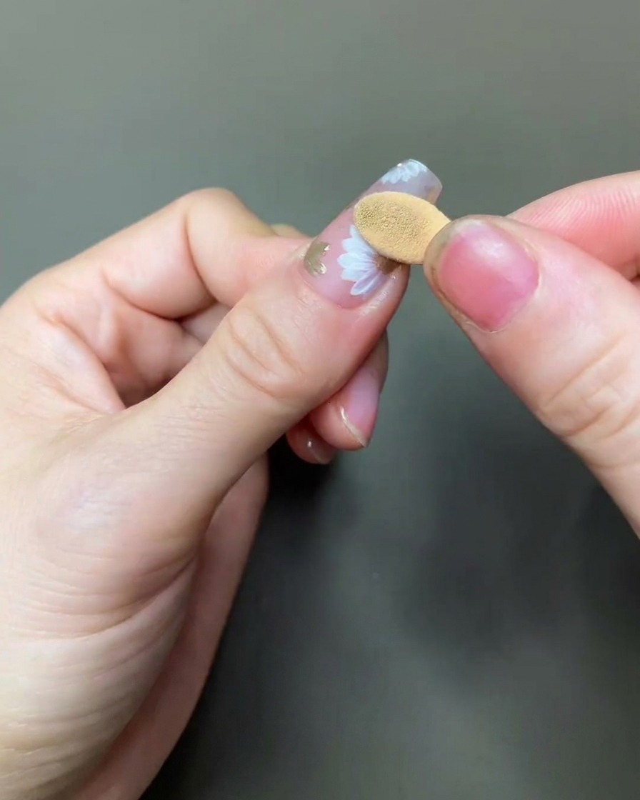 チップを使って、デイジーの中心にゴールドのクロムパウダーを擦り込んでいる様子。