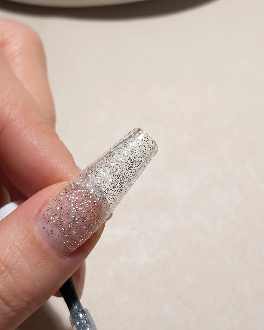 シルバーのラメ入りジェルを爪全体に塗っている様子。