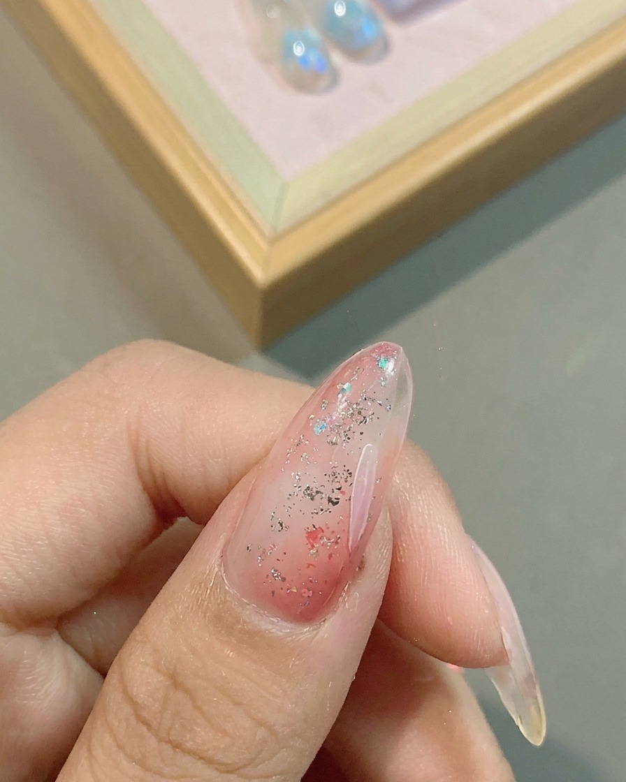 細筆を使い、ピンクベースの上に白い花びらを描く様子。