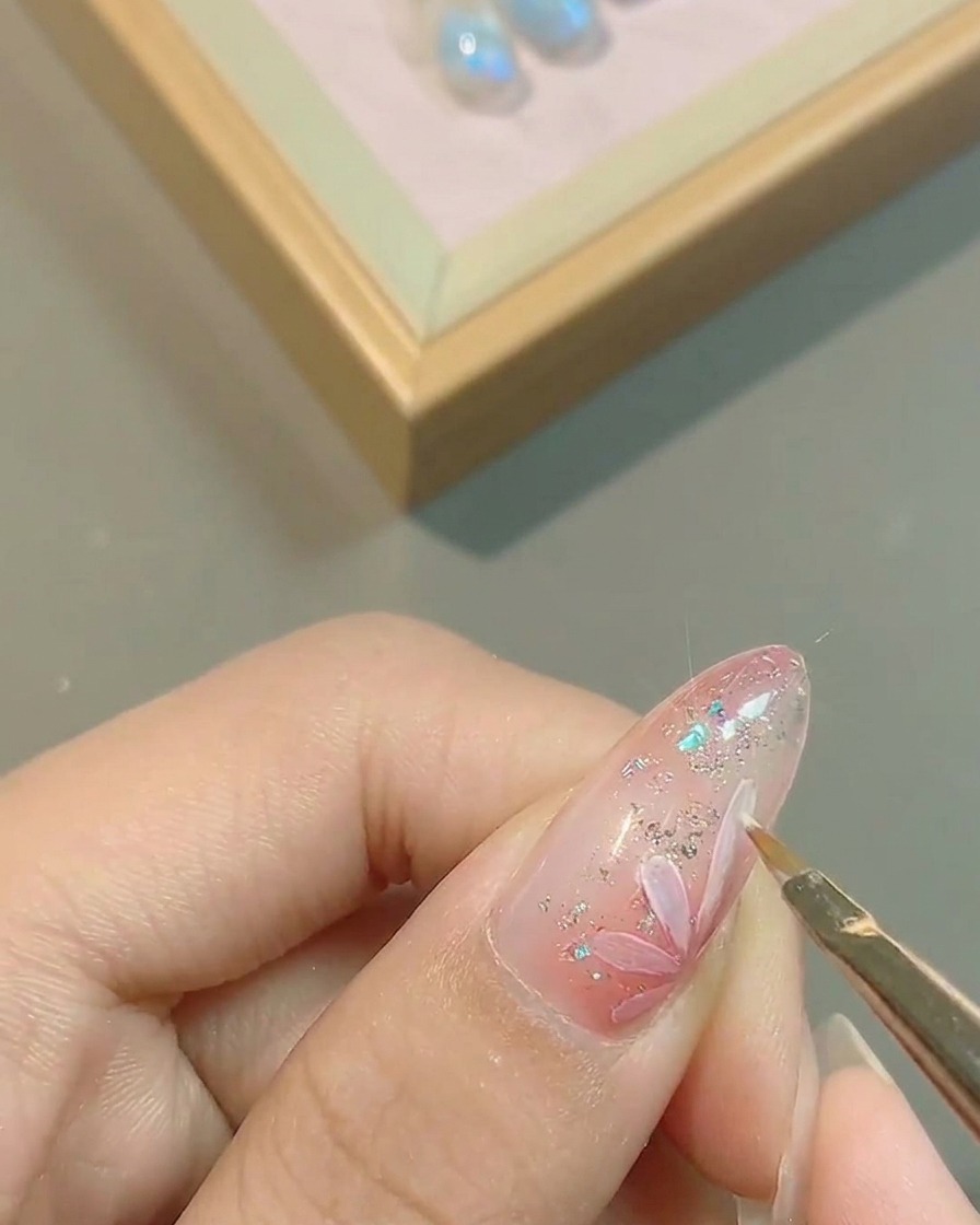 描いた白い花びらの輪郭を細筆で整える様子。