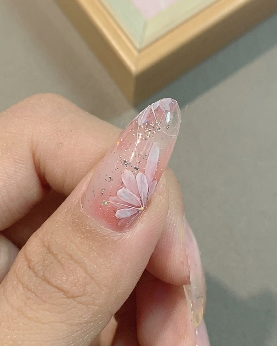 細筆でデイジーの花びらに繊細なラインを描き足す様子。