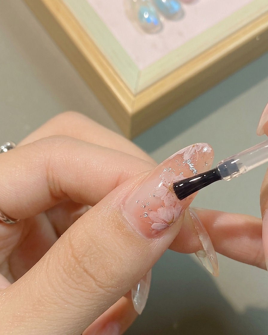 花の中心にメタリックシルバーのジェルを点置きする様子。