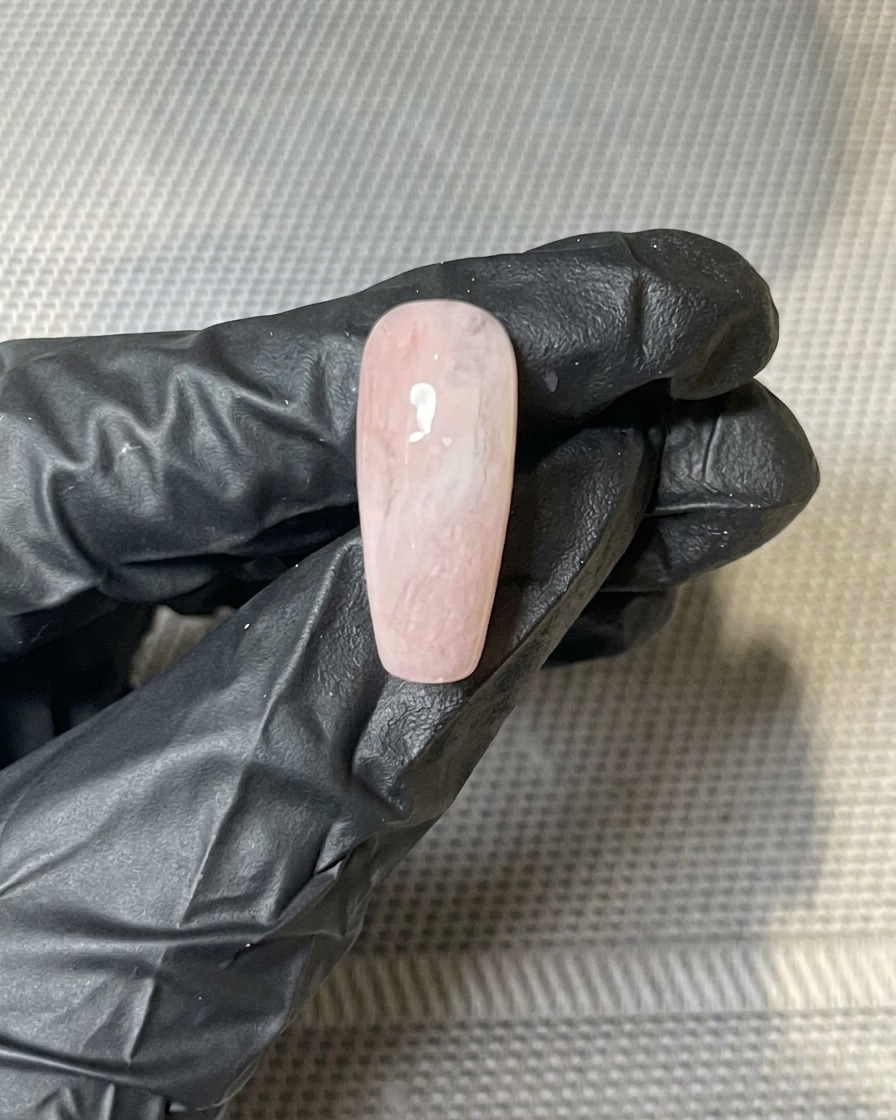 硬化後のネイルの未硬化部分に、ピンセットでゴールドホイルを配置している様子。