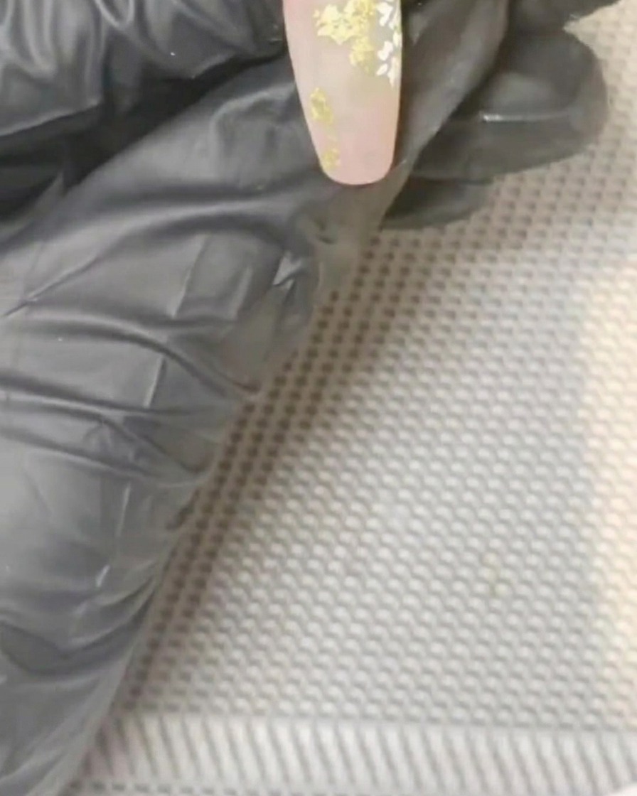 ドット棒を使い、花の中心に黄色のジェルを点在させている様子。