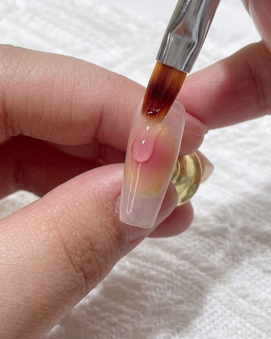 グラデーションの中心にピンクジェルを少量追加して深みを出している様子