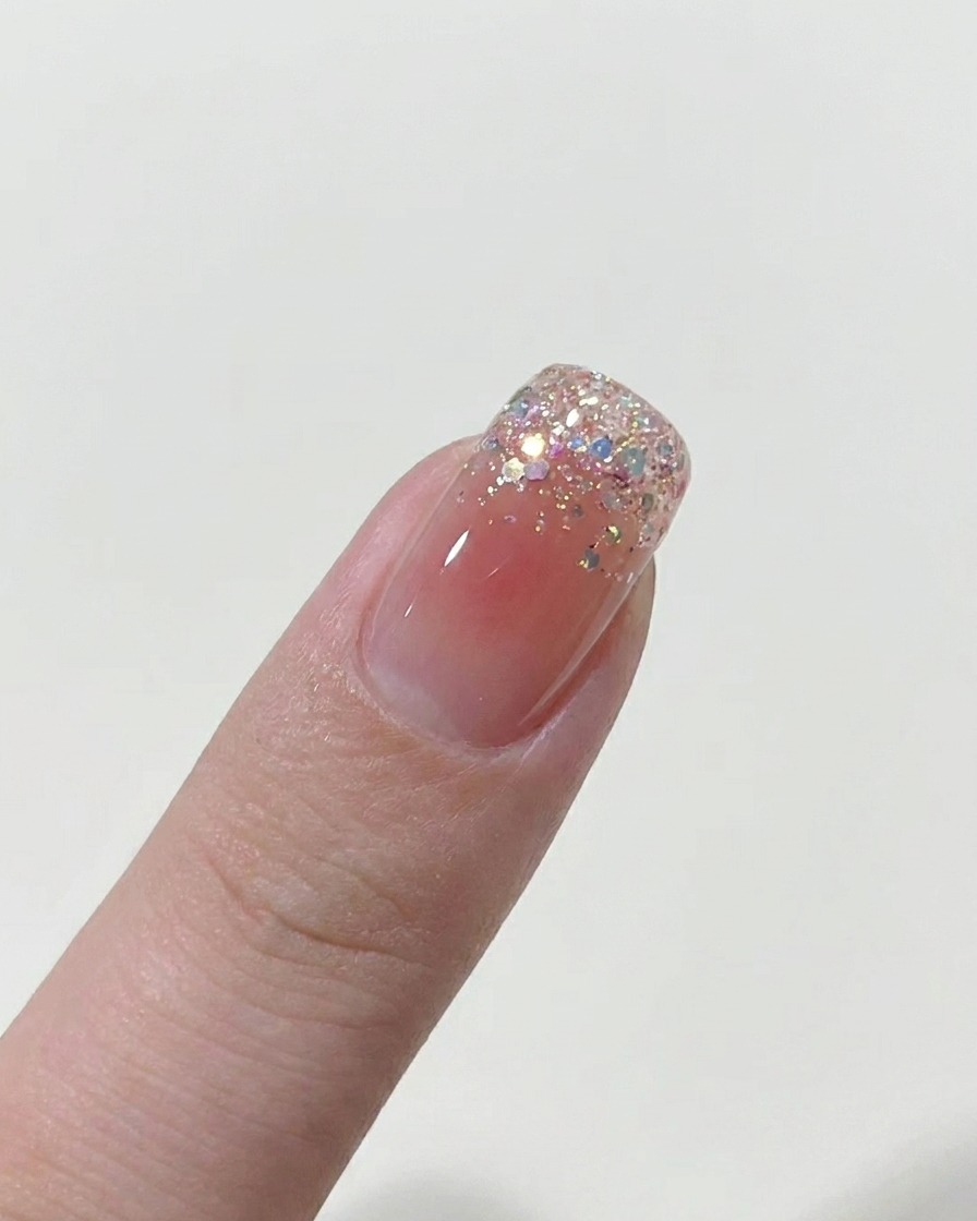 自爪に薄くヌードカラーのジェルを塗っている様子