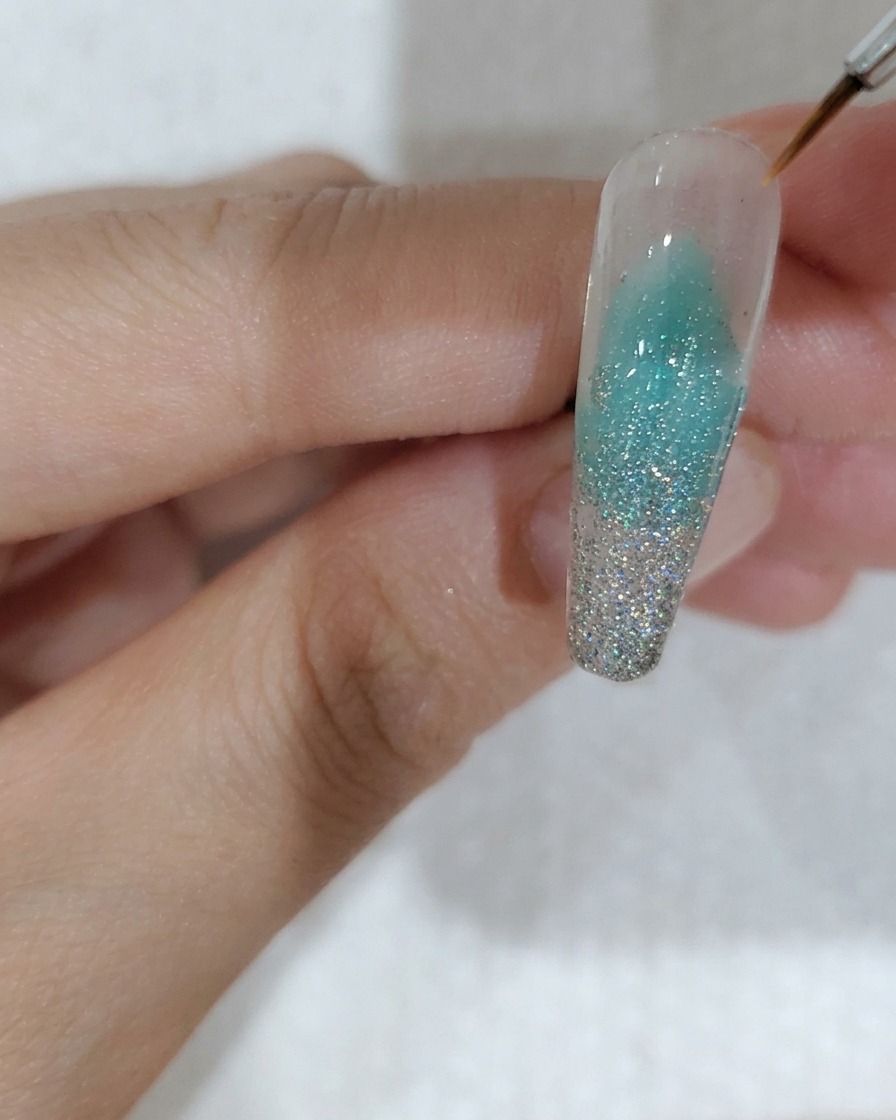 ピンセットで桜型のホログラムを1枚置いている様子
