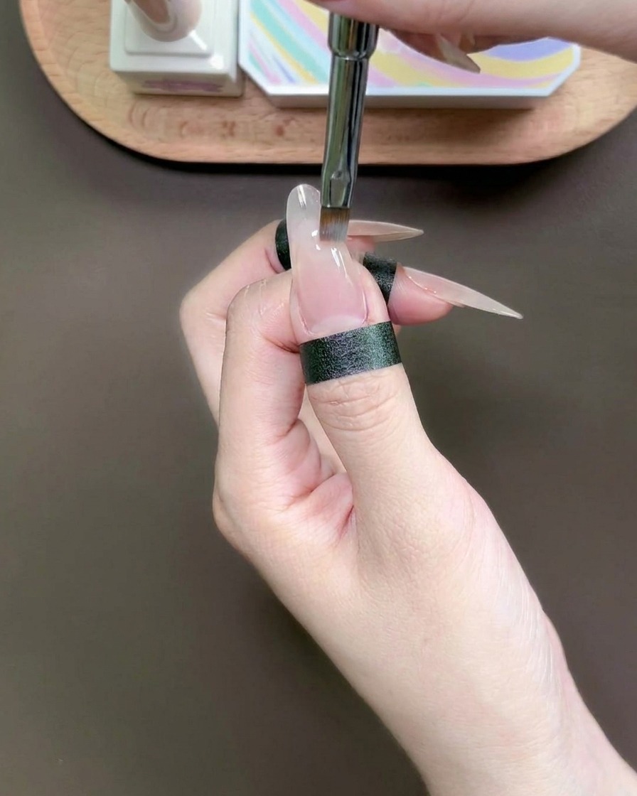 専用のスポンジツールを使って、爪先にブルーのジェルをのせている様子。