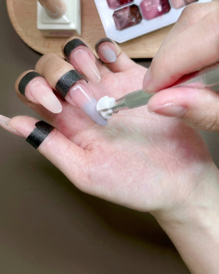 スポンジツールを使ってブルーのジェルをぼかし、オンブレ効果を作っている様子。