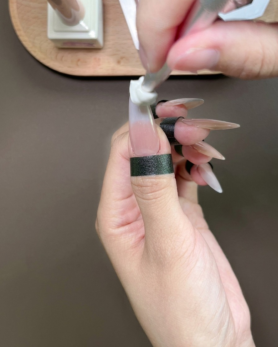親指の爪先にスポンジツールでブルージェルを叩き込み、グラデーションを作っている様子。