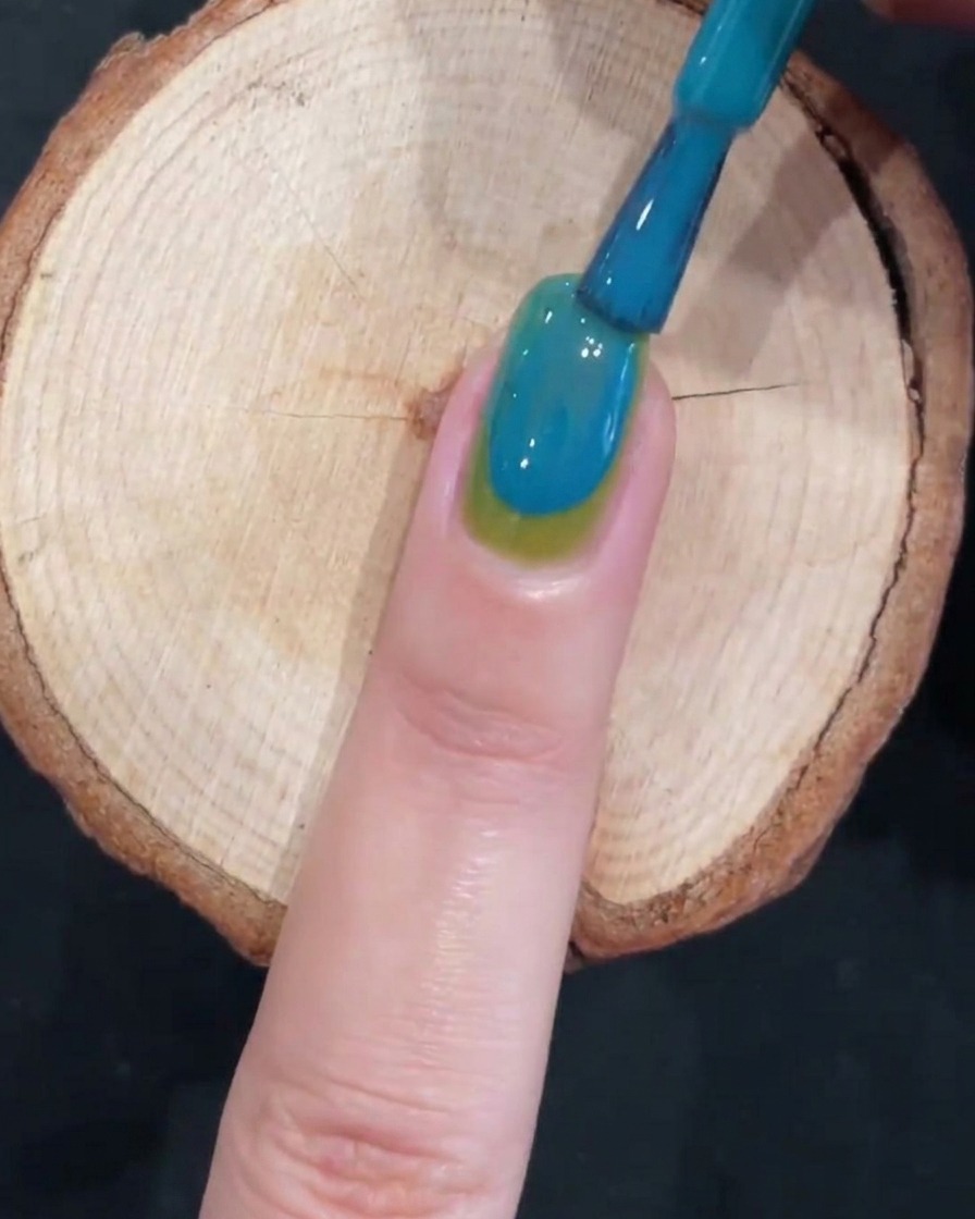 ブルーとグリーンが滑らかに繋がったグラデーションネイルの様子。