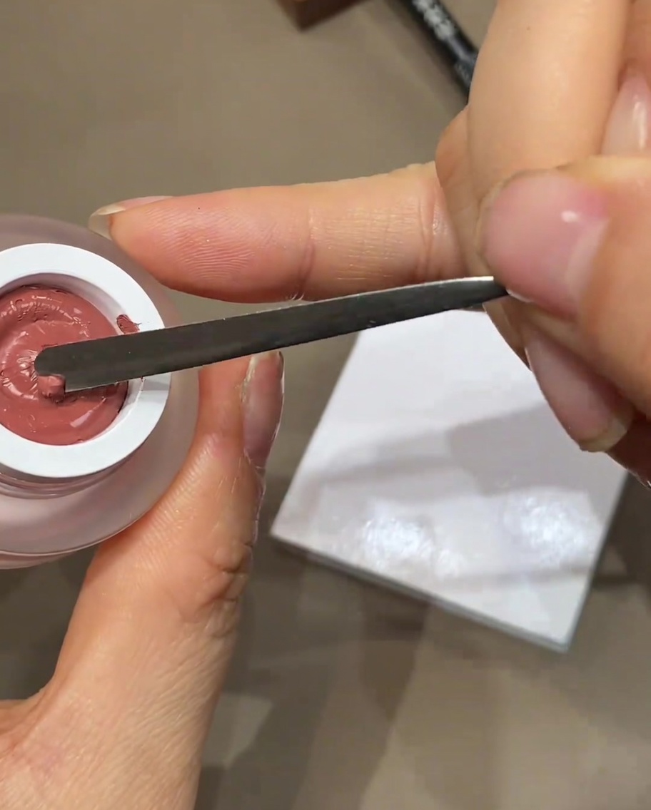 メタルスパチュラで、パレットの上に少量カラージェルを出している様子。
