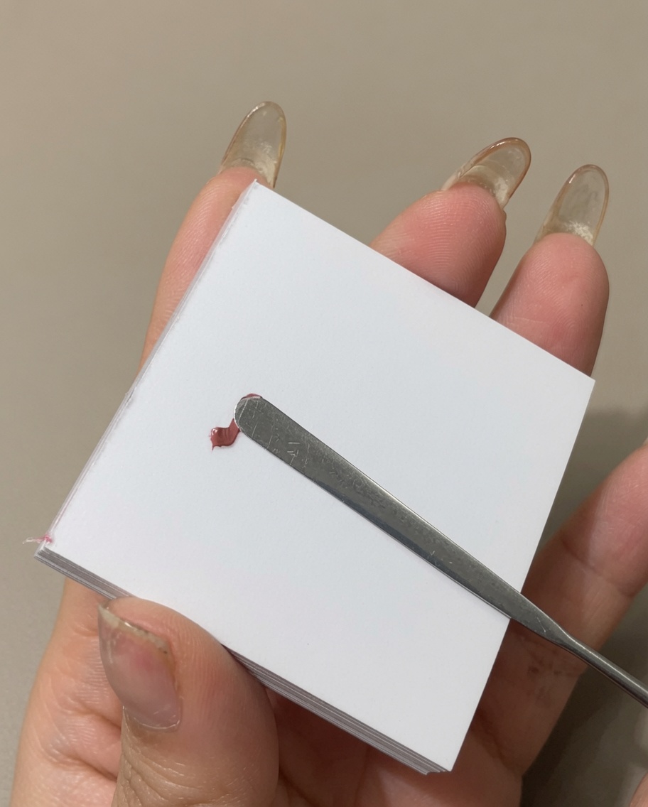 メタルスパチュラを使って、パレット上でジェルを横長に薄く広げている様子。