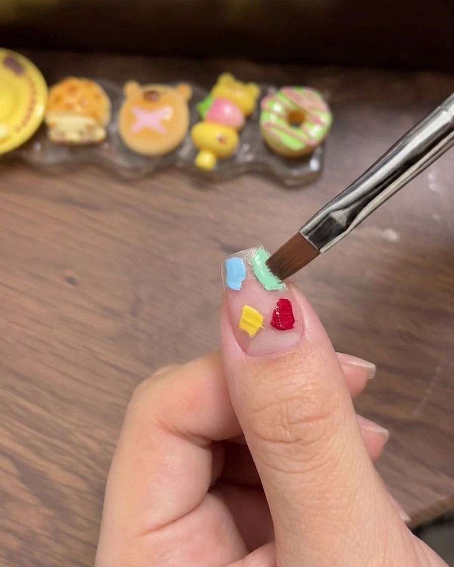 小さな白いメイク用スポンジで、配置したジェルを優しく叩いてグラデーションを作っている様子