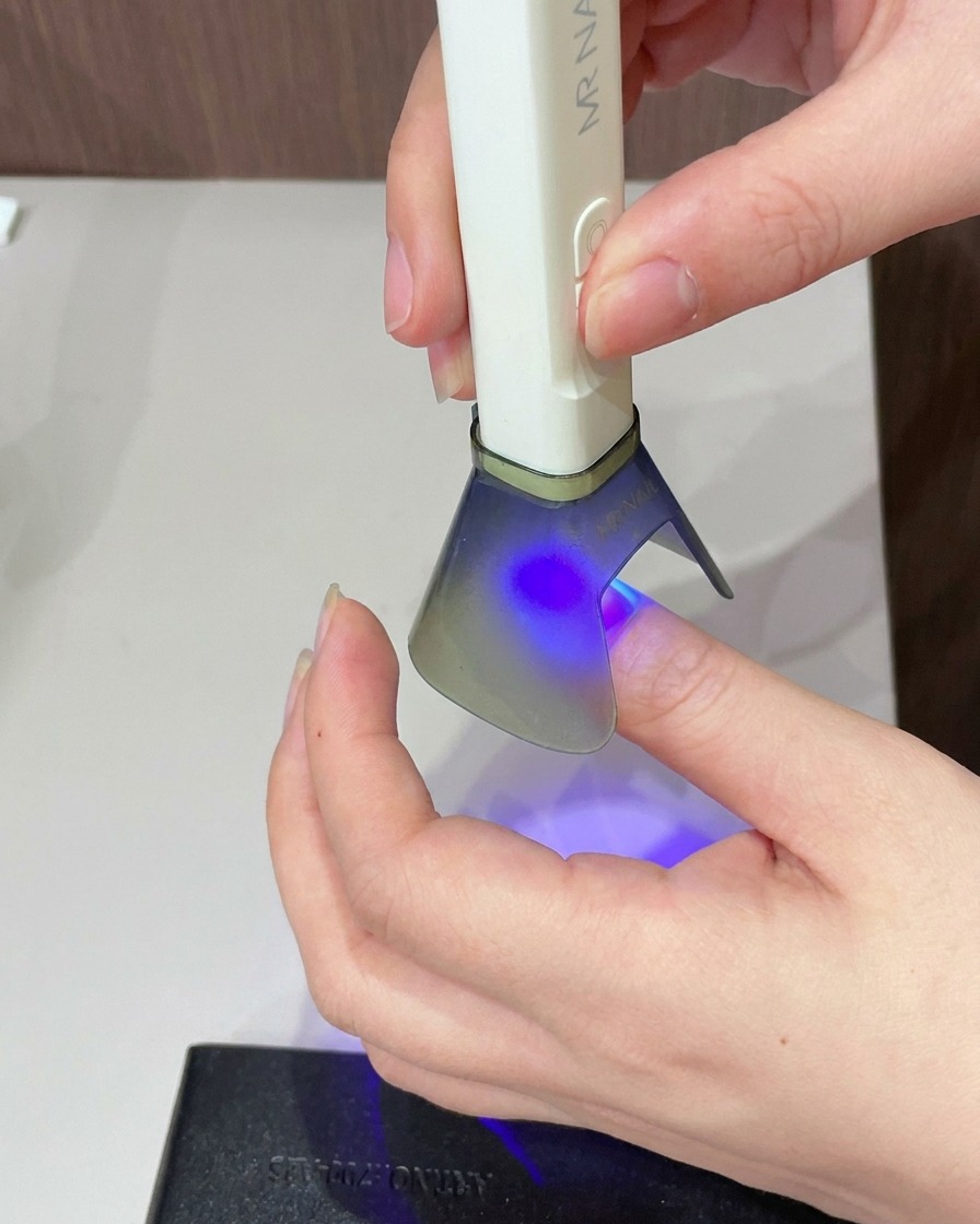 爪全体に透明なキャッツアイジェルを筆で塗っている様子