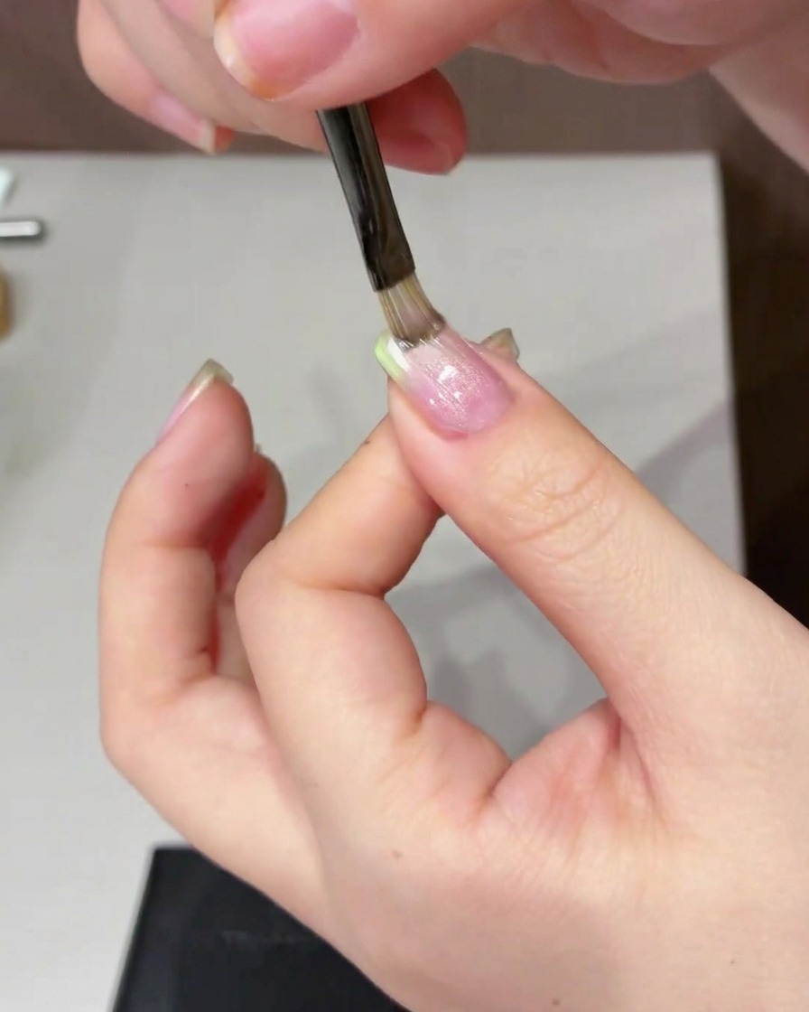 円柱状のマグネットを爪の横で左右に動かし模様を作っている様子