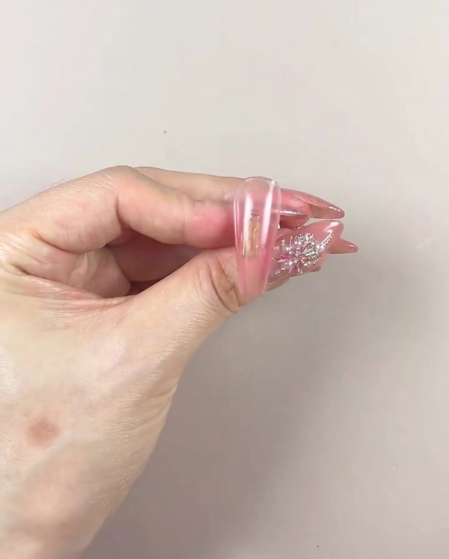 UV/LEDランプの中に手を入れ、ジェルを硬化させている様子。