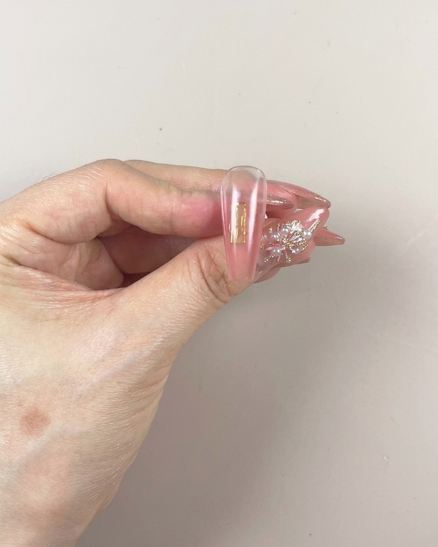 筆で爪の先端部分にジェルを塗り足している様子。